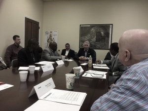 Group of professionals engaged in a meeting around a conference table.