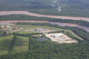 Aerial view of a river, trees, and a factory.