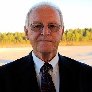 Elderly gentleman in a suit and tie posing for a photograph.