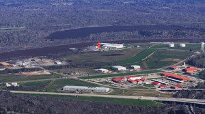 Aerial view of a rural landscape with agricultural and industrial facilities near a river.